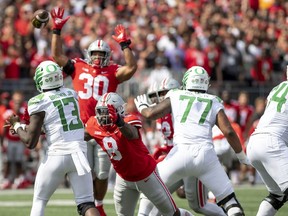 COLUMBUS, OH - SEPTEMBER 11: Quarterback Anthony Brown #13 of the Oregon Ducks throws a pass as defensive end Javontae Jean-Baptiste #8 of the Ohio State Buckeyes lunges to block him at Ohio Stadium on September 11, 2021 in Columbus, Ohio.