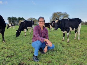 Researcher Lindsay Matthews next to cows at a farm in New Zealand.