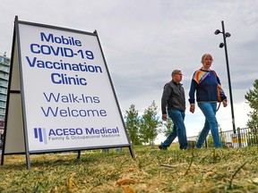 Signs mark a City of Calgary mobile COVID-19 vaccination clinic in Eau Claire near the Peace Bridge on Wednesday, September 22, 2021.