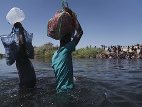 Migrants cross the Rio Grande River near the Del Rio-Acuna Port of Entry in Acuna, Coahuila state, Mexico, on Monday, Sept. 20, 2021. The U.S. flew Haitians camped in a Texas border town back to their homeland Sunday and tried blocking others from crossing the border from Mexico in a massive show of force that signaled the beginning of what could be one of America's swiftest, large-scale expulsions of migrants or refugees in decades, reports the Associated Press.