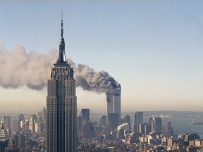 The twin towers of the World Trade Center burn behind the Empire State Building in New York on Sept. 11, 2001.