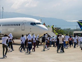 Haitian migrants board an airport bus after U.S. authorities flew them out of a Texas border city after crossing the Rio Grande river from Mexico, at Toussaint Louverture International Airport in Port-au-Prince, Haiti September 21, 2021.