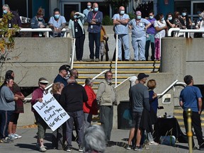 Some hospital staff observe the more than 100 people that showed up Sept. 13, 2021, for a national day of protest against mandatory vaccinations at the Royal Alexandra Hospital.