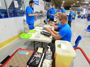 Medical staff prepare supplies at the pop-up COVID-19 vaccination clinic at the Village Square Leisure Center in northeast Calgary on Sunday, June.  6, 2021.