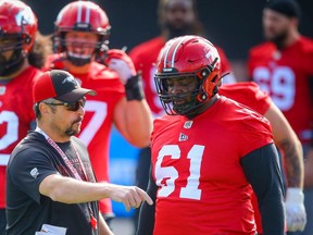 Stampeders offensive coordinator & offensive line coach Pat DelMonaco and Ucambre Williams chat during practice in Calgary earlier this month.
