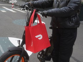 A DoorDash delivery person is pictured on the day they hold their IPO in the Manhattan borough of New York City, New York, U.S., December 9, 2020. REUTERS/Carlo Allegri ORG XMIT: PPPNYC205