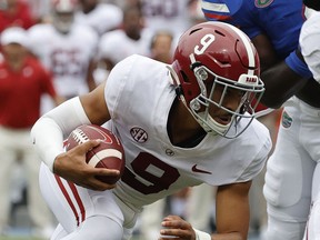 Alabama Crimson Tide quarterback Bryce Young runs with the ball against the Florida Gators during the first quarter at Ben Hill Griffin Stadium.