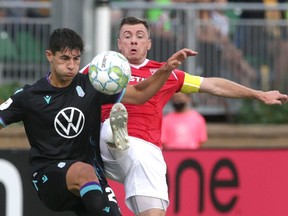 Pacific FC's Alessandro Hojabrpour (at left) and Cavalry FC's Nik Ledgerwood battle for a loose ball during CPL soccer action at ATCO Field in Calgary in this photo from Aug. 11.