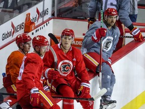 A group of players hop over the boards during Calgary Flames training camp on Thursday.