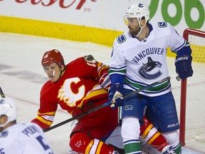 Calgary Flames Matthew Tkachuk, left, collides with Vancouver Canucks Erik Gudbranson in NHL hockey action at the Scotiabank Saddledome in Calgary,  on Saturday October 6, 2018. Leah Hennel/Postmedia