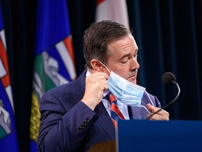 Premier Jason Kenney removes his mask prior to announcing the province’s new COVID measures at McDougall Centre in Calgary on Friday, Sept. 3, 2021.