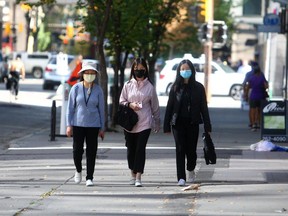 People are seen wearing masks while walking along 8th Ave. S.W. Tuesday, September 7, 2021.