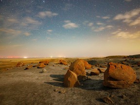 Stars and clouds in the sky over concretions lit by moonlight at Red Rock Coulee Natural Area south of Seven Persons, Ab., on Monday, August 30, 2021.