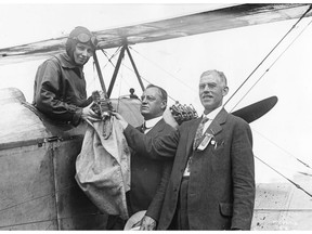 Katherine Stinson hands over a mail bag to postmaster George Armstrong and W.S. Starke, manager of the Edmonton Exhibition. She became the first civilian to fly the mail in Canada on this 1918 flight from Calgary to Edmonton. Postmedia archives, photo courtesy McDermid Studios.