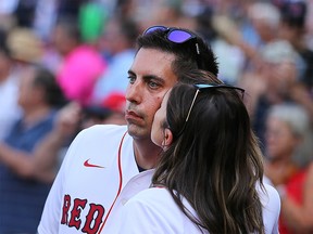 Kelsie Snow plants a kiss on the cheek of her husband, Chris, a former Red Sox beat writer for the Globe who now works as an NHL executive