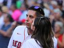 Kelsie Snow plants a kiss on the cheek of her husband, Chris, a former Red Sox beat writer for the Globe who now works as an NHL executive.