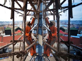 A labourer navigates wooden scaffolding erected for the construction of a new modern 9-story building in downtown Kampala, Uganda, in 2012. Between 2001 and 2018, Africa imported US$250-billion worth of goods.