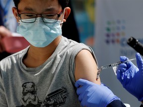 FILE PHOTO: Brendan Lo (13) receives a dose of the Pfizer-BioNTech vaccine for the coronavirus disease (COVID-19) at Northwell Health's Cohen Children's Medical Center in New Hyde Park, New York, U.S., May 13, 2021.