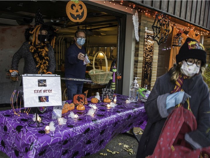  Bev Hall and Don Jackson use a hockey stick and a basket to hand out candy to trick-or-treaters in Montreal West during Halloween last year.