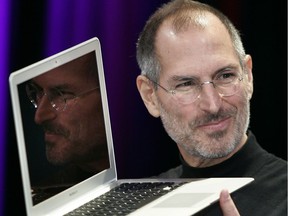 On this day in history in 2011, Steve Jobs, the Apple founder and former CEO who invented and masterfully marketed ever-sleeker gadgets that transformed everyday technology — from the Mac to the iPod, iPhone and iPad — died at age 56. In this photo, Jobs shows off the then-new Macbook Air ultra portable laptop during his keynote speech at the MacWorld Conference & Expo in San Francisco 15 January 2008.            AFP PHOTO/Tony AVELAR