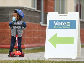 Jediah Ncube, 3 yrs, arrives with his dad to vote at Saddle Ridge School in northeast Calgary on Monday, October 18, 2021 to cast their ballot in Calgary's municipal election.  Jim Wells/Postmedia