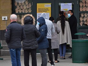 Voter line up at a polling station in the Sspomitapi riding (formerly Ward 12) at Father Michael Troy School in Edmonton on Monday, Oct. 18, 2021.