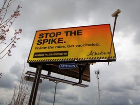 An Alberta government billboard advertisement promotes vaccination and adherence to COVID-19 rules.