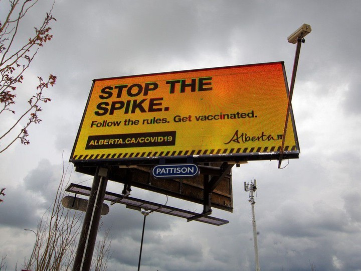  An Alberta government billboard advertisement promotes vaccination and adherence to COVID-19 rules.