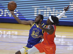 Golden State Warriors' Andrew Wiggins, left, shoots against Oklahoma City Thunder's Luguentz Dort during the first half of an NBA basketball game in San Francisco, Saturday, May 8, 2021.