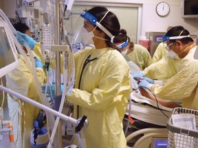 Teams in a crowded Calgary intensive care unit tend to a COVID-19 patient on a ventilator in 2021.