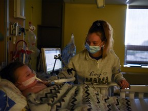 Tiffany Jackson comforts her son Adrian James, 2, who tested positive for the coronavirus disease (COVID-19), as he breathes with assistance from a ventilator at SSM Health Cardinal Glennon Children's Hospital in St. Louis, Missouri, U.S., October 5, 2021.