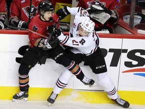 The Calgary Hitmen’s Oliver Tulk battles the Red Deer Rebels’ Dallon Melin at the Scotiabank Saddledome in Calgary on Friday, Oct, 15, 2021.