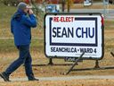 A pedestrian walks past a Sean Chu campaign sign in Ward 4 on voting day in the municipal election, Monday 18 October 2021. 