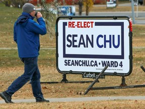 A pedestrian walks past a Sean Chu campaign sign in Ward 4 on voting day in the municipal election, Monday, October 18, 2021.