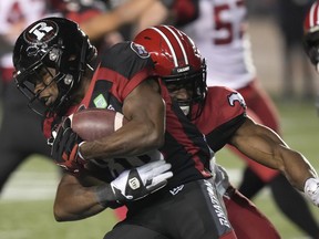 Calgary Stampeders defensive lineman Silas Stewart tackles Ottawa Redblacks wide receiver Nate Behar at TD Place Stadium in Ottawa on Friday, Oct. 29, 2021.