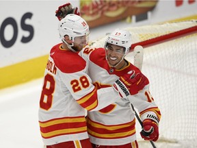 The Calgary Flames’ Elias Lindholm (28) celebrates with left Johnny Gaudreau after scoring the game-winning goal in overtime against the Washington Capitals at Capital One Arena in Washington on Saturday, Oct. 23, 2021.