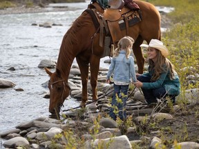 In the Season 15 opener on Heartland, Amy (Amber Marshall) and Lyndy (played by twins Ruby and Emmanuella Spencer) ride to the stream. Courtesy, Heartland Season 15.