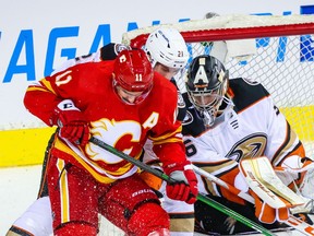 Calgary Flames centre Mikael Backlund battles with the Anaheim Ducks' Isac Lundestrom in front of Ducks goaltender John Gibson at the Scotiabank Saddledome on Monday.