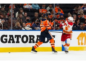 Edmonton Oilers' Darnell Nurse (25) battles Calgary Flames' \f61\ during second period preseason NHL action at Rogers Place in Edmonton, on Monday, Oct. 4, 2021. Photo by Ian Kucerak