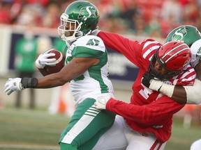 Stamps Mike Rose tackles Roughrider's William Powell during CFL football action between the Saskatchewan Roughriders and the Calgary Stampeders at McMahon Stadium in Calgary on Saturday, October 2, 2021. Jim Wells/Postmedia