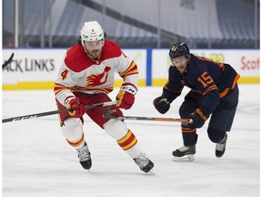 Edmonton Oilers Josh Archibald (15) and Calgary Flames Rasmus Andersson (4) skate for the puck during second period NHL action on Saturday, May 1, 2021 in Edmonton.