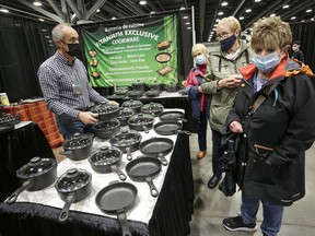 People look at some cookware products at the Vancouver Fall Home Show at Vancouver Convention Centre on Oct. 14, 2021. After the cancellation last year due to the COVID-19 pandemic, the convention operated this year under health safety protocols.