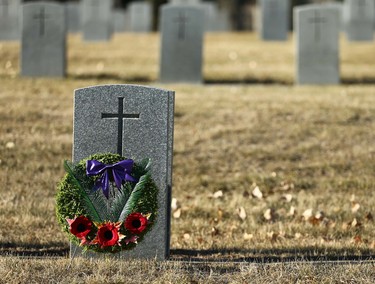 A wreath decorated with poppies rest in the afternoon sunlight at Burnsland Cemetary in Calgary on Thursday, November 11, 2021. Jim Wells/Postmedia