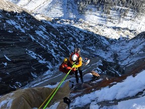 Kananaskis Country Public Safety officials make their way down the mountain to rescue an injured BASE jumper.