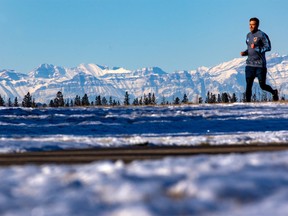 The Rockies rise behind a runner in Calgary’s North Glenmore Park on Monday, November 1, 2021.