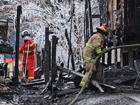 Calgary firefighters deal with the aftermath of a two-alarm fire that damaged two homes in the 6600 block of Coach Hill Rd SW at about 2 a.m. on Sunday, November 21, 2021. All of the residents were able to safely escape the blaze.