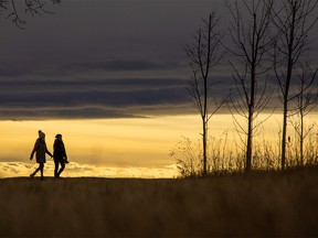 Calgarians walk under a late afternoon chinook arch in North Glenmore Park on Sunday, November 21, 2021.