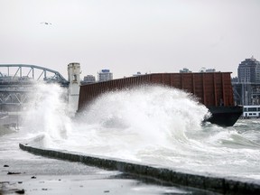 Waves crash against the sea wall where a barge came loose from its mooring was driven ashore by high winds after rainstorms lashed the western Canadian province of British Columbia in Vancouver, British Columbia, Canada November 15, 2021.