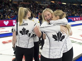 Skip Jennifer Jones hugs 2nd Jocelyn Peterman after defeating team Fleury 6-5 in extra end of the curling trials.