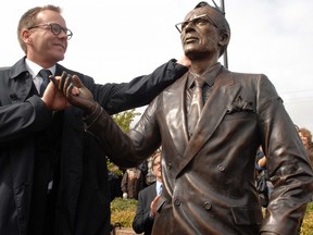 On this day in 1961, the Saskatchewan legislature passed a law giving that province Canada's first pre-paid medical care plan. This 2010 photo shows actor Kiefer Sutherland, grandson of former Saskatchewan premier Tommy Douglas, beside a statue of Douglas. Douglas represented the Weyburn constituency during his time as premier from 1944 to 1961, but he is most commonly known for bringing universal health care to Canada and being voted as "The Greatest Canadian" in a national television competition, (Don Healy / Leader-Post)